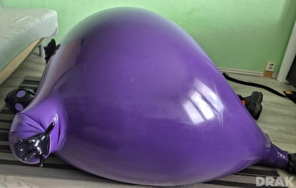Inflated purple hazmat suit playing on the ground unable to get up