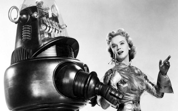 Robby, the robot from the 1950s sci-fi film, Forbidden Planet, accompanied by his date, actress Anne Francis, on the red carpet for the 1957 Academy Awards. Black and white photograph.
https://wallpaperaccess.com/full/5182349.jpg