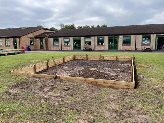Sand pit with no sand in it.  Instead it’s a muddy puddle with wood around it.