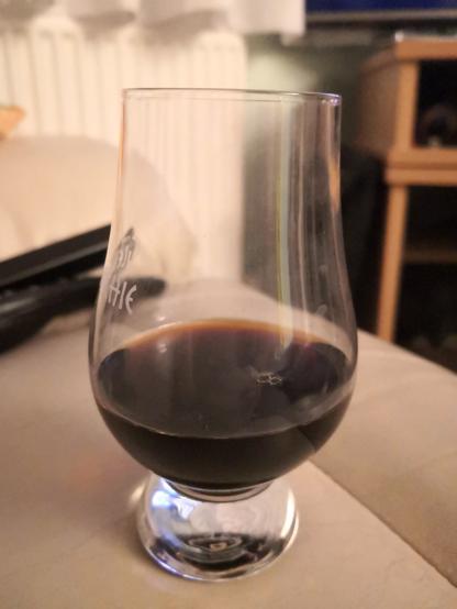 Photo of a Glencairn whisky glass with the black liqueur in it