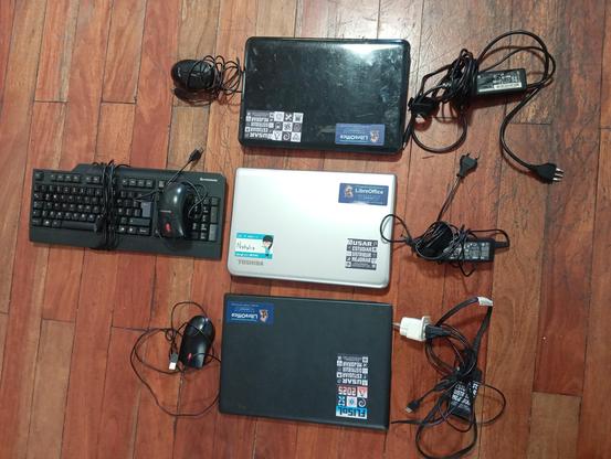 Tres laptops, sus respectivos cargadores, un teclado y tres mouses. Las Laptops tienen algunos adhesivos que promueven las cuatro libertades del Software Libre