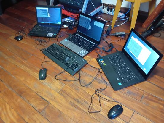 Tres Laptops en funcionamiento con Linux Mint. Cada una de ellas tiene una terminal abierta realizando actualizaciones. Más tres están conectadas con mouses y especialmente una de ellas tiene conectado un teclado USB.