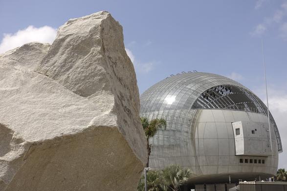 “levitated mass” boulder with dome of the Oscar museum in background.
