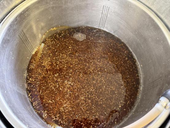 Looking down into the mash tun with amber wort circulating on the grain bed