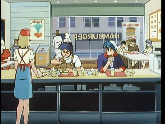 Kento and Rowen are sitting as a counter at a burger joint. Kento is wearing brown overalls and a white tee, and Rowen is wearing a blue jacket with red lining and a backwards cap. We can see the back of an attendent, in a blue dress, white shirt, and red hat. You can see the red straps of her appron crossing her back. Both Rowen and Kento have a tray with a drink on it, and both have burgers in their hands. But Kento's tray is also littered with several containers from already eaten burgers.