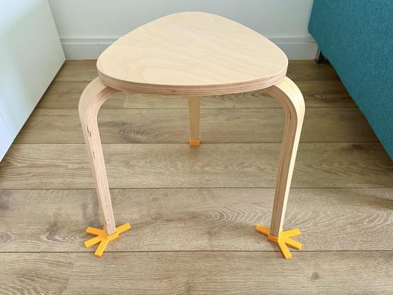 3D printed yellow minimalist pigeon feets on a Kyrre Ikea 3 legged stool