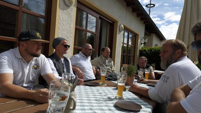 ein paar Männer sitzen beim Wirt am Tisch bei einem Bier