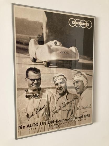 Reproduction 1938 poster featuring the Auto Union Typ C on an Autobahn high speed run. Also Rosemeyer and other leading Auto Union drivers