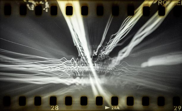 Long exposure light trails in a highway gallery, shot on misprocessed (as BW) Rollei CR200 colour film with a modded Holga. Sprockets are visible on the film.