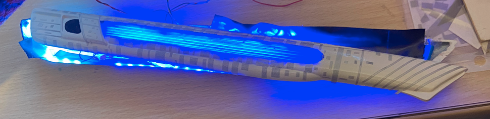 One of the nacelles being tested to make sure the circuit is correct. The light is clearly passing through the clearcoat blue painted area. This was painted instead of left white because then the model would still look good even if the model isn't connected to power.