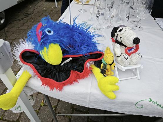 Snoopy und Woodstock mit einer Mütze mit einem blauweißroten Hahn.