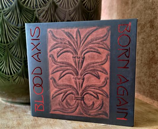 CD digipak cover on a table with a green flower pot behind it.

"Blood Axis" written vertically on the left side in red, large letters. 
"Born Again" written the same way on the right side.

In the middle, a black and red image of an embossed plant like figure.