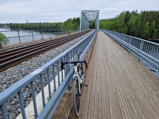 Pyörä kävelysillan kaidetta vasten. Vieressä menee junarata.