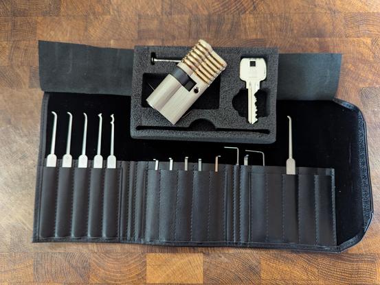 A lock picking set in a black pouch and a practice lock.