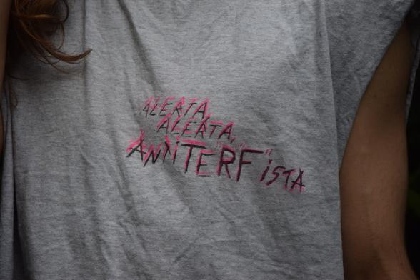 Closeup of chest area of the same grey shirt from before, with 'Alerta, Alerta AntiTERFista printed in two offset prints, in pink and black.