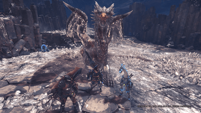 Drei Jäger stehen vor dem Drachenältesten Namens Kushala Daora im Tal der Ältesten. Der Drache liegt bequem auf dem Boden und schaut direkt in die Kamera. Er sieht ziemlich freundlich aus, auch wenn er alles andere als freundlich ist. Das Tal der Ältesten ist übersäht mit Energie-Kristallen, weshalb überall am Boden spitze Kristalle hervorragen.
