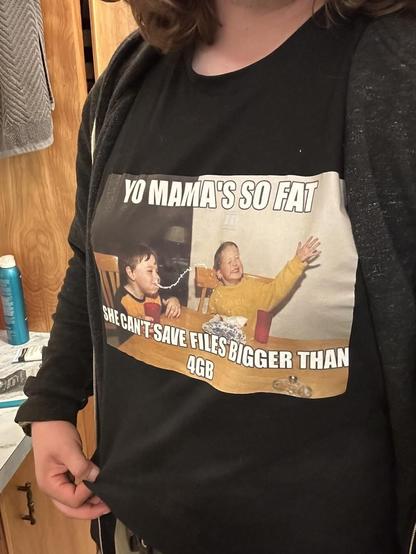 A woman wearing a shirt that says "Yo Mama's so far she can't save files bigger than 4GB."