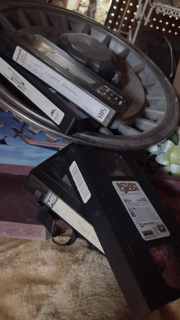 A bunch of VHS tapes laying over stuff.
