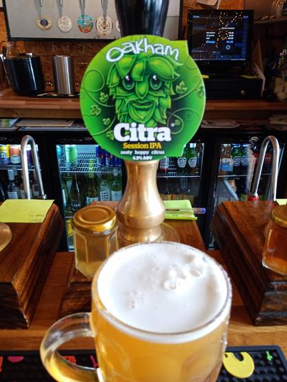 A pint of @oakhamales.bsky.social Citra real ale in front of its pumpclip in fab 1260 pub, Liscard, Wirral