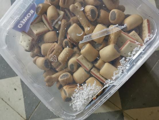 Bak met hondenkoekjes. De rand is opengevreten.