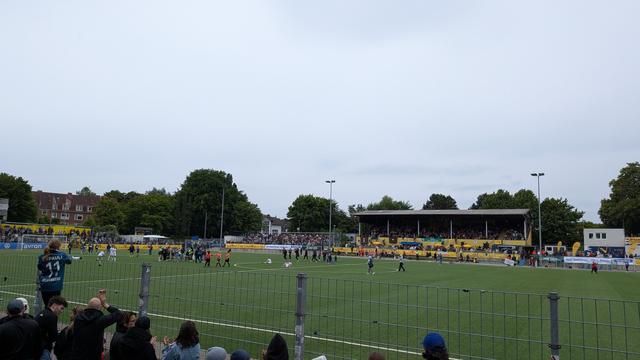 Einige Spielerinnen auf dem Boden sitzend, die anderen jubeln.