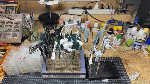 Parts of a Ford Escort RS Cosworth 4x4 by Tamiya on top of a cutting mat on top of a workbench. All parts are clamped and are waiting for painting.