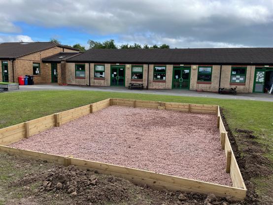 Sandpit with pea-shingle at the bottom.