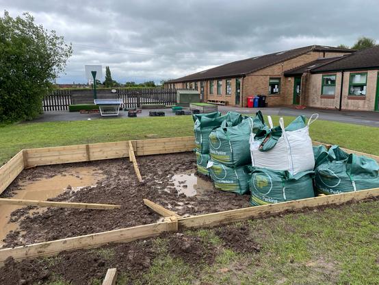 Sandpit with pea-shingle in bags.