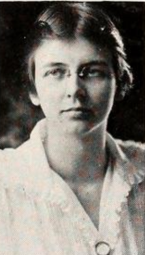 Lillian Gest, from the 1919 yearbook of Vassar College; a young white woman with short hair, wearing glasses and a white collared blouse with a ruffle trim