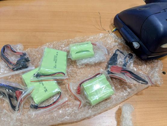 a bunch of ni-mh battery packs next to a vintage Polaroid camera.