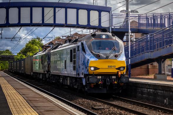 DRS Class 88s, 88010 and 88008 hauling a long intermodal train up towards Coatbridge FLT. 88010 is named "Aurora" and has a special livery, saying "Refrigerated Rail. Cool Move." on it's side