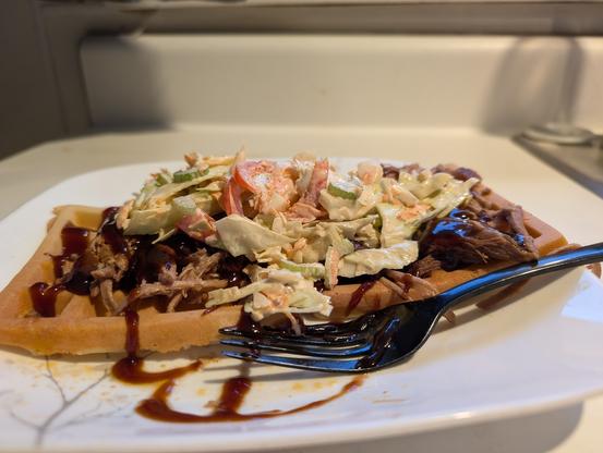 A Belgian waffle, plied high with pulled pork,BBQ sauce, and hoemade coleslaw.