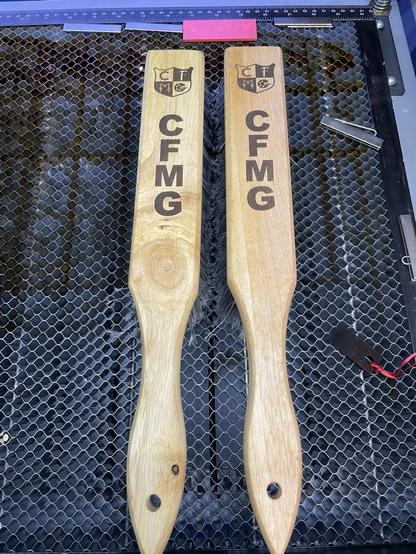 Picture of the 2 finished brushes side by side in the bed of the laser.