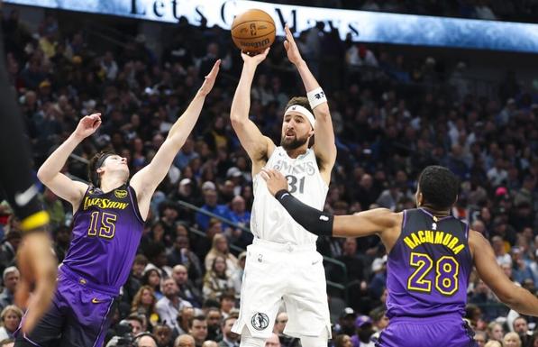 Jan 7, 2025; Dallas, Texas, USA; Dallas Mavericks guard Klay Thompson (31) shoots over Los Angeles Lakers guard Austin Reaves (15) and Los Angeles Lakers forward Rui Hachimura (28) during the first half at American Airlines Center. Mandatory Credit: Kevin Jairaj-Imagn Images