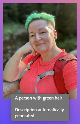 A person with short, bright green hair poses outdoors, leaning on a wooden railing with one hand resting under their chin. They are wearing a bright pink-red shirt and a backpack with red straps. The background is softly blurred, showing trees and nature in warm sunlight.
Below there is a caption in white letters on gray background which says: "A person with green hair. Description automatically generated"