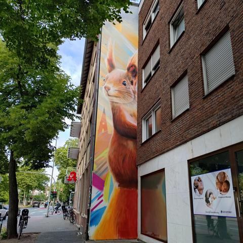 foto der wandfläche auf einem kleinen vorsprung eines hauses mit einem graffiti eines eichhörnchens über drei etagen
