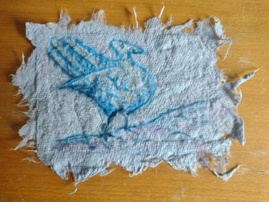 Drawing of a bit turkey-like fantasy bird in blue on coarse, lighter blue handmade paper with deckled edges.