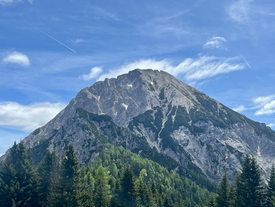 Blick zu einem massiven Felsgipfel mit blauem Himmel