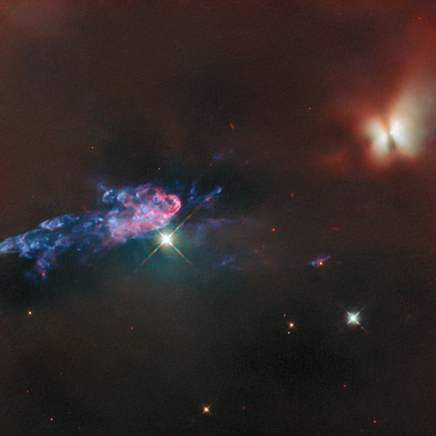 From source link in toot: An area in the Orion nebula filled with dark, puffy clouds. On the left side a large area of clouds, crossed by a dark bar, is lit up in red and whitish colours by a protostar within. At the other side a large jet of material ejected by the protostar appears, made of thin, wispy, blue and pink clouds. A couple of foreground stars shine brightly in front of the nebula