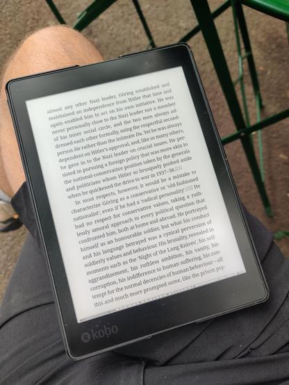 My beloved Kobo Aura ONE on my lap, displaying a page of an e-book in KOreader.