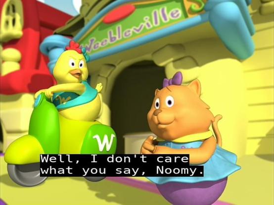 Still from Weebles episode "The Wednesday Race" (2005). Zuzie Q. (yellow hen with no legs in teal crop top) on a yellow and green scooter and Noomie (orange cat with no legs wearing a light blue dress, purple bottom, and purple hair bow) are arguing in front of a yellow Town Center building over who's the fastest Weeble in all of Weebleville. The EIA-608 (line 21) caption has a spelling error: "Well, I don't care what you say, Noomy."
