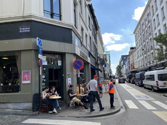 vue d’une vélorue de Bruxelles avec quelques tables en terrasse