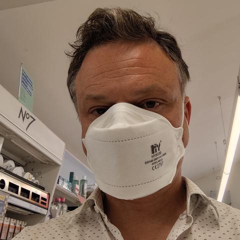 Man wearing FFP3 mask in a pharmacy.