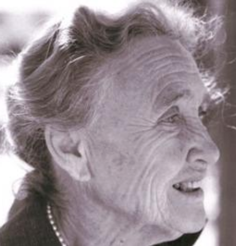 Elizabeth Kellam de Forest late in life; an older white woman with wavy grey hair, smiling, photographed in near profile, wearing pearls