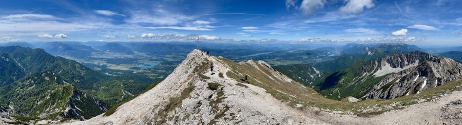 Bergpanorama mit Blick ins Tal des Klagenfurter Beckens mit einigen Seen und vielen Bergen rundum