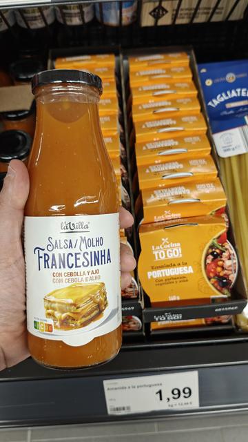 Pot de vidre de salsa per "francesinha". Al fons una llauna etiquetada com "amanida a la portuguesa"