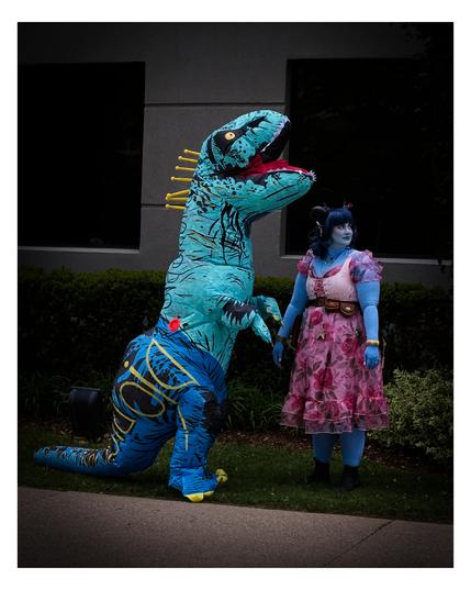 Dinosaur and blue fairy cosplay hanging out.