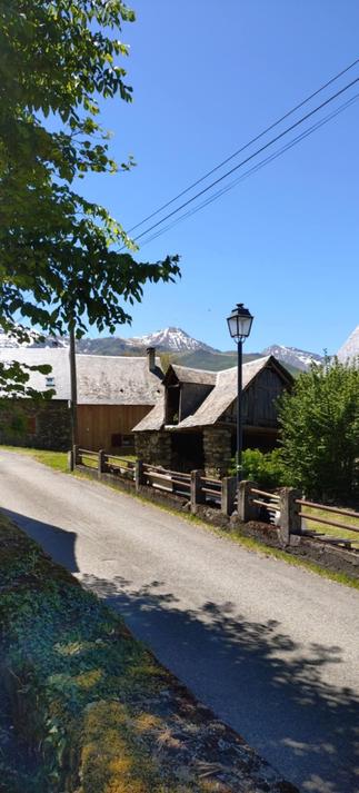 Vue de la rue principale de Loudervielle, dans la vallée du Louron, dans les Hautes Pyrénées.
Au premier plan une maison, et derrière un pic enneigé.