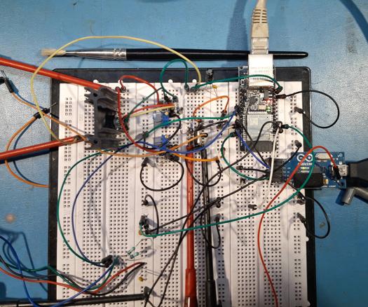 An electronics breadboard with various kinds of components: a small and densely populated pcb with an ethernet connection, another small pcb with a USB connection, and various discrete components.