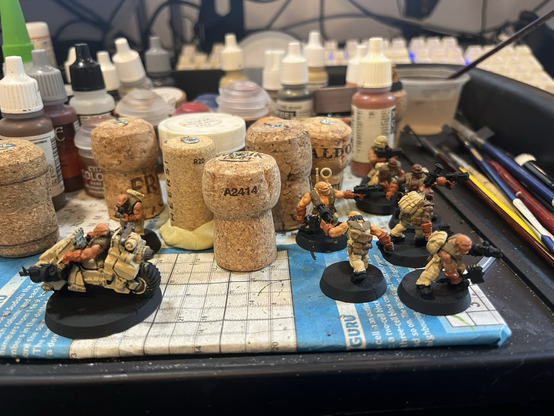 Some partially painted desert dwarf minis on a painting table.